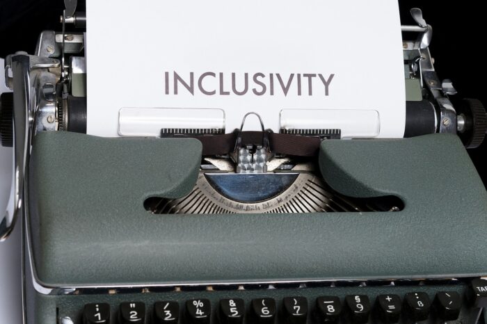 Une machine écrire avec une feuille sortant sur laquelle est écrit "inclusivity" illustrant un article sur l'inclusivité digitale 